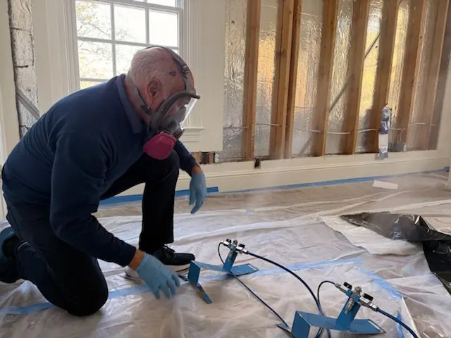 A restoration technician setting drying equipment in an Carlsbad home stripped to the studs