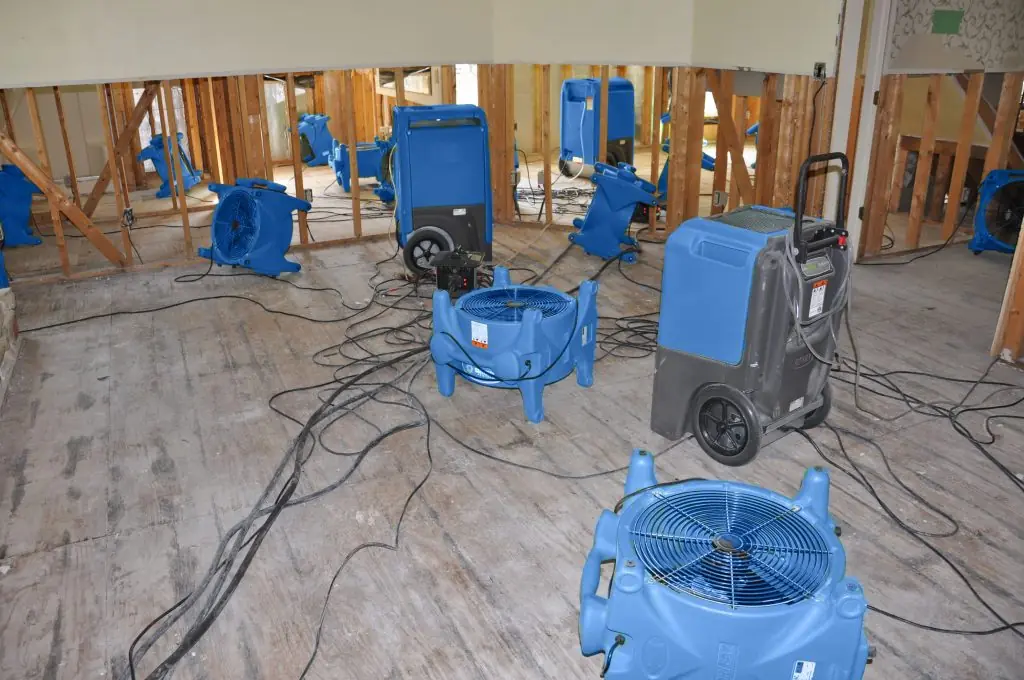 Air movers drying a gutted Carlsbad room after major water damage